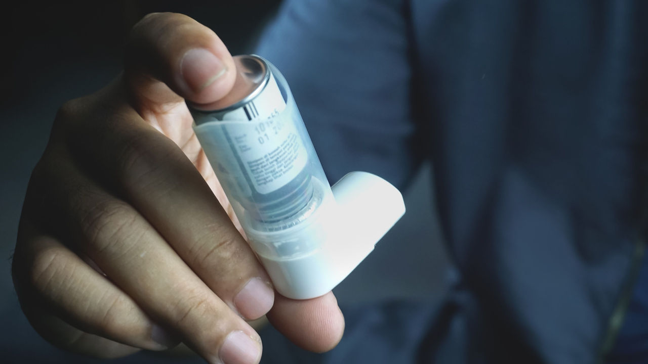 A closeup of a male hands holding asthma inhaler - Medical equipment concept; Shutterstock ID 2300931303; purchase_order: 7-9-24; job: Medical sustainability white paper ; client: Envalior ; other: 